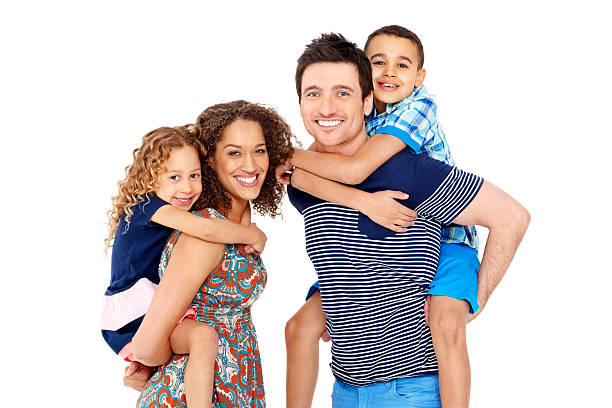 iconFam2 Portrait of playful young parents giving piggyback ride to children on white background